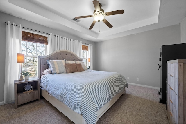 bedroom with visible vents, ceiling fan, baseboards, carpet floors, and a raised ceiling