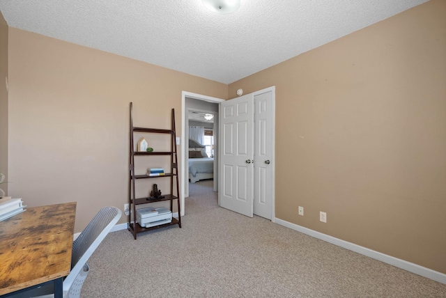 office area featuring carpet flooring, baseboards, and a textured ceiling