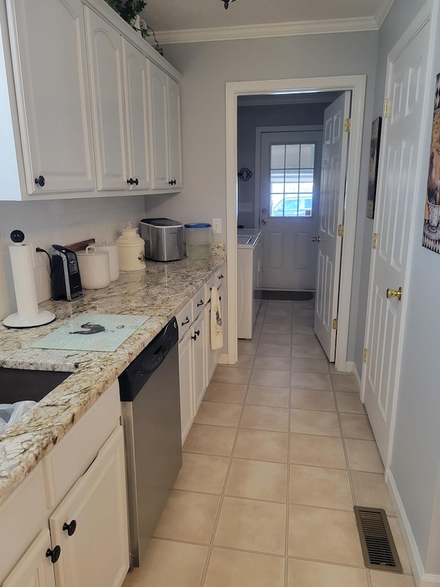 kitchen featuring visible vents, crown molding, dishwasher, light tile patterned floors, and washer / dryer