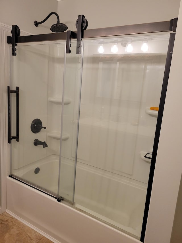 bathroom with combined bath / shower with glass door and tile patterned flooring