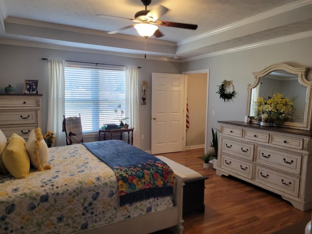 bedroom with crown molding, a raised ceiling, and wood finished floors