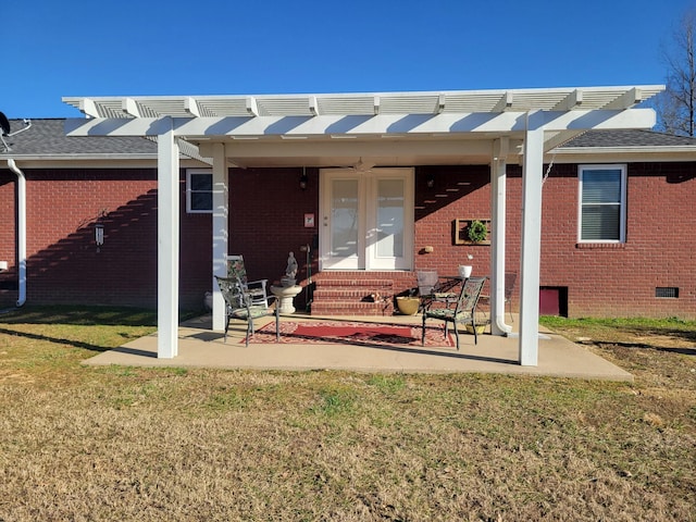 rear view of property featuring a yard, brick siding, a patio area, and a pergola