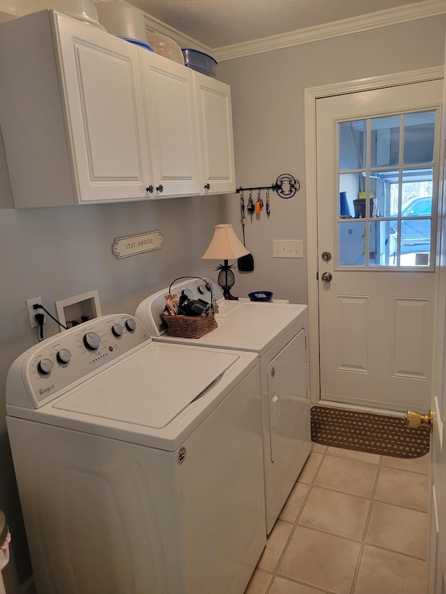 clothes washing area featuring light tile patterned floors, cabinet space, crown molding, and separate washer and dryer