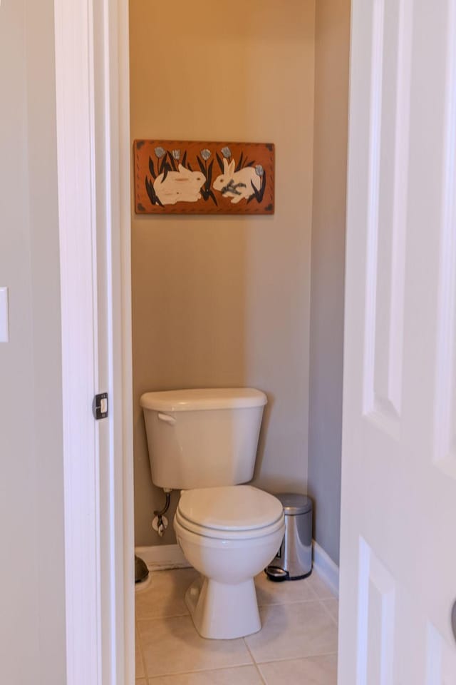 bathroom with tile patterned floors, baseboards, and toilet