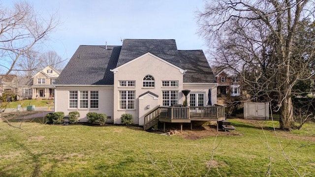 back of house with a deck, a lawn, and stucco siding