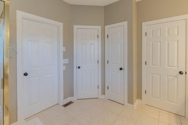 unfurnished bedroom with light tile patterned floors, visible vents, and baseboards