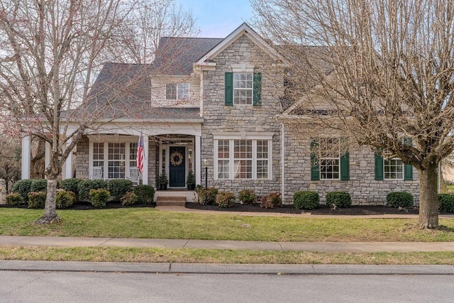 view of front of home featuring stone siding and a front lawn