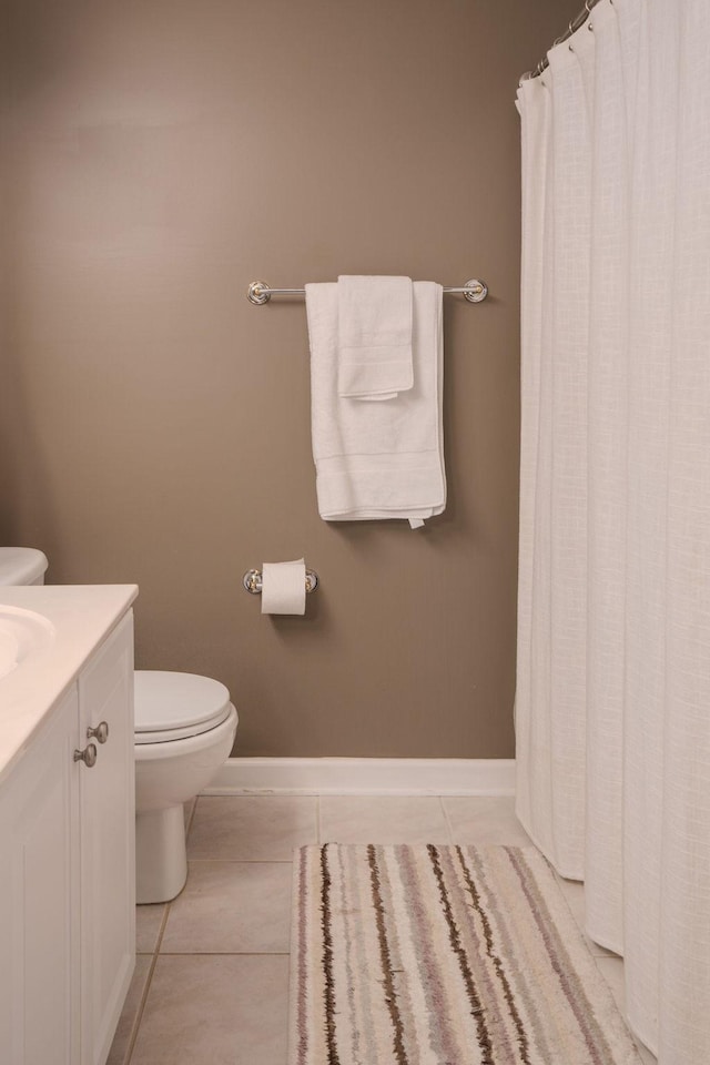 full bathroom featuring tile patterned flooring, toilet, vanity, and baseboards