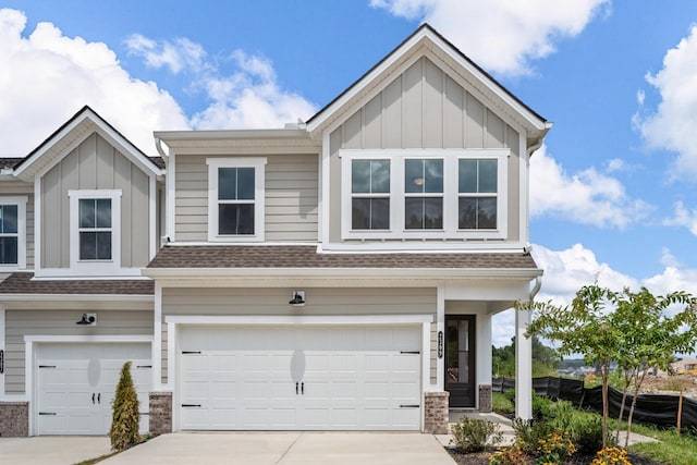 view of front of house with board and batten siding, concrete driveway, a garage, and a shingled roof