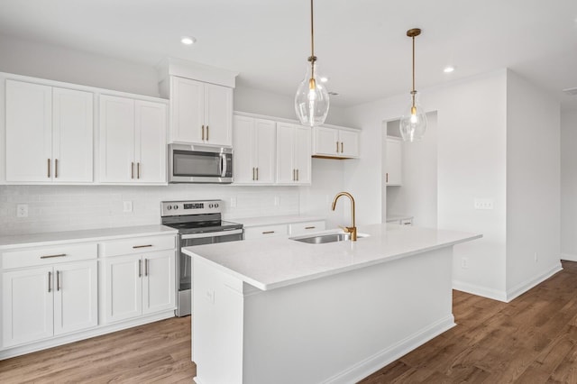 kitchen featuring a sink, decorative backsplash, light wood-style flooring, and stainless steel appliances