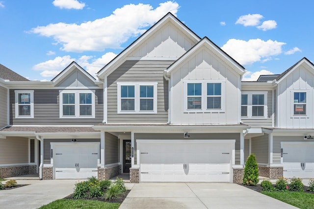 multi unit property with board and batten siding, concrete driveway, and an attached garage