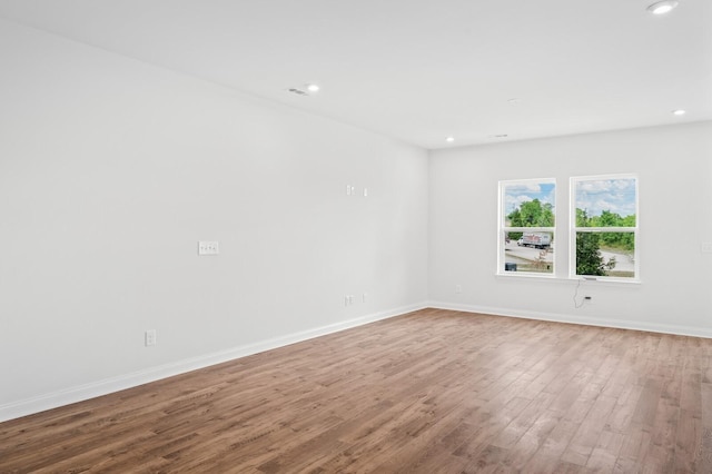 unfurnished room with recessed lighting, baseboards, and wood finished floors