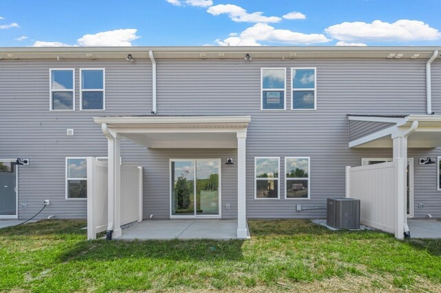 back of house with fence, a lawn, central AC unit, and a patio area