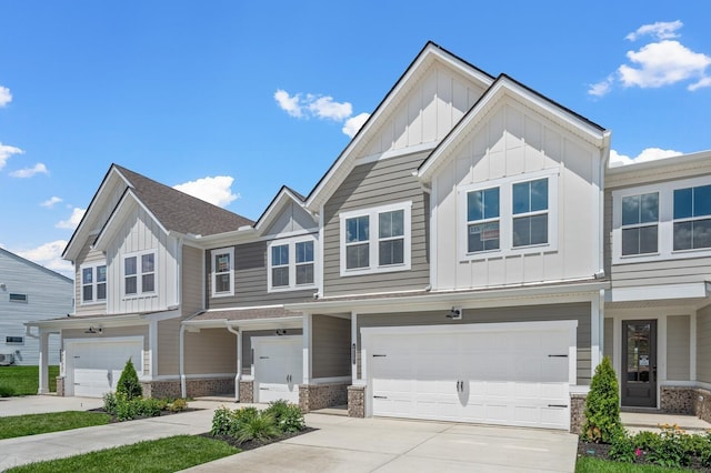 multi unit property with board and batten siding, driveway, a garage, and roof with shingles