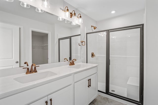 bathroom with marble finish floor, a stall shower, and a sink