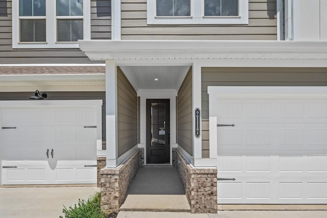 doorway to property with a garage and stone siding