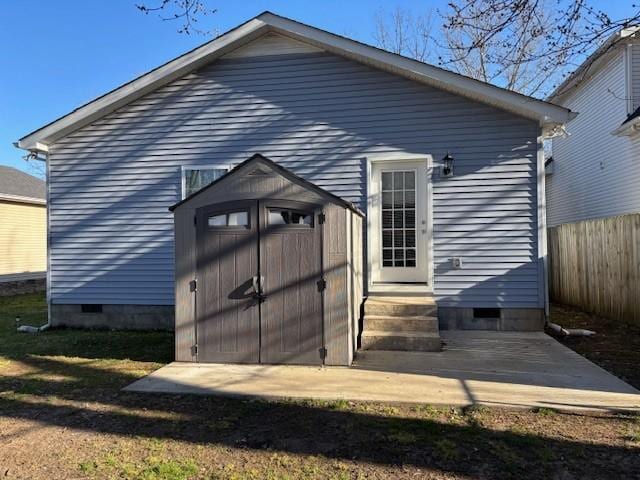 view of shed with entry steps and fence