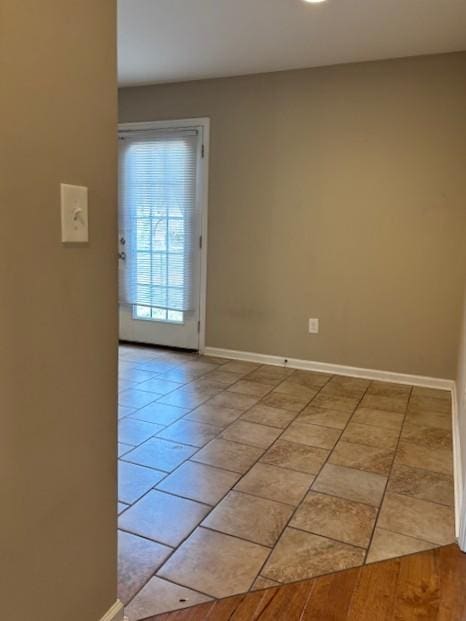 unfurnished room with baseboards