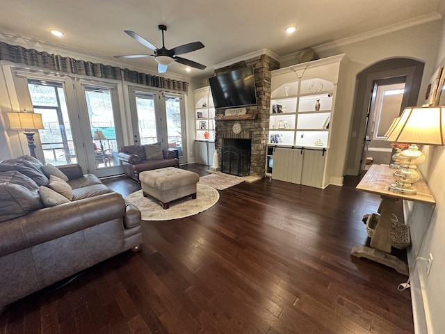 living room featuring ornamental molding, recessed lighting, a fireplace, wood finished floors, and a ceiling fan