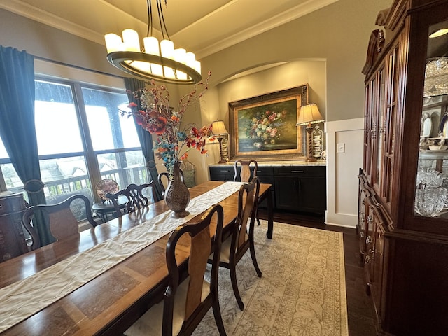 dining space featuring a chandelier, crown molding, and wood finished floors