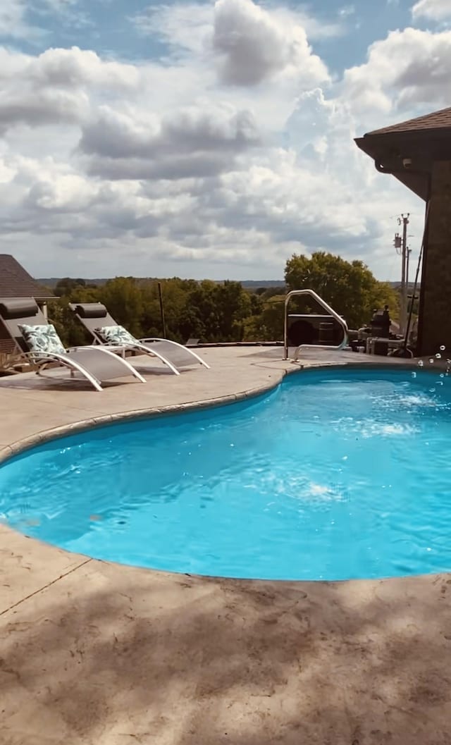 outdoor pool with a patio area