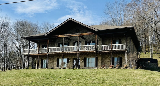 rear view of house featuring brick siding, a wooden deck, and a yard