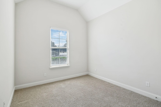 unfurnished room featuring lofted ceiling, baseboards, and carpet floors