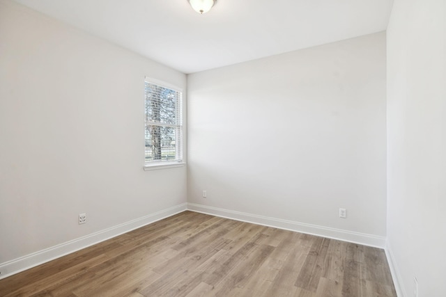 unfurnished room featuring baseboards and light wood-style flooring