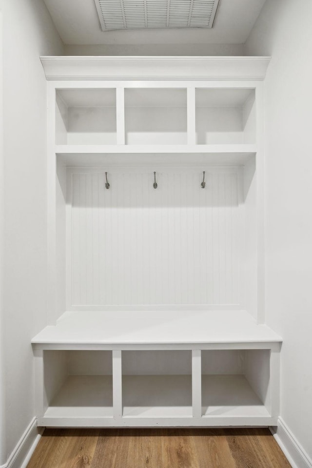 mudroom featuring visible vents, baseboards, and wood finished floors