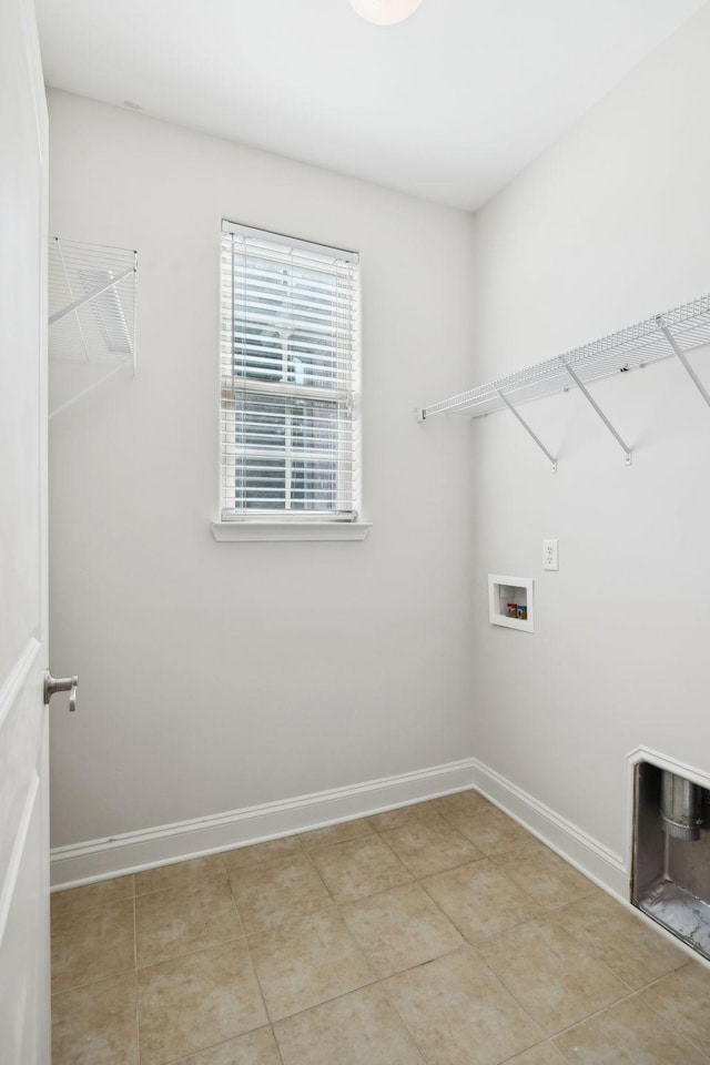 clothes washing area featuring washer hookup, laundry area, light tile patterned flooring, and baseboards