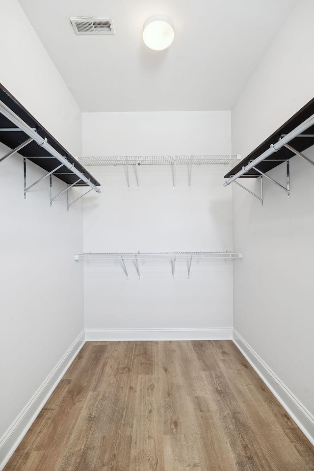 walk in closet with visible vents and wood finished floors