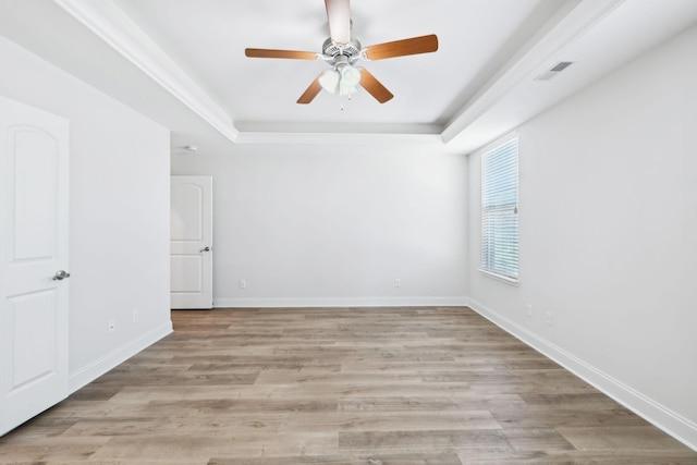 unfurnished room featuring visible vents, baseboards, light wood-style floors, and a tray ceiling