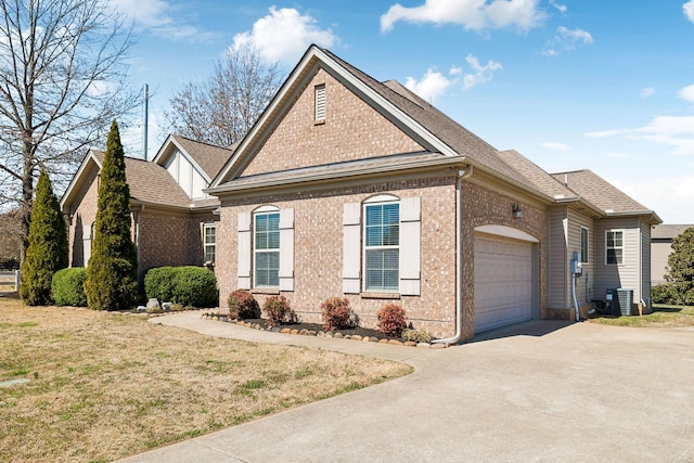 traditional-style home featuring brick siding, driveway, an attached garage, and roof with shingles