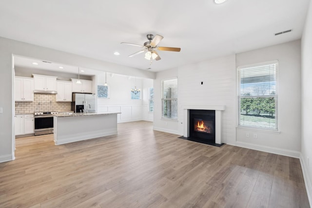 kitchen featuring visible vents, tasteful backsplash, open floor plan, stainless steel appliances, and light wood finished floors