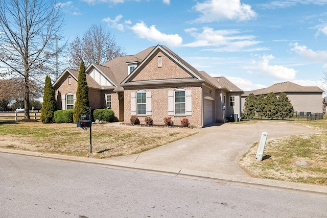 view of front of home with brick siding, fence, a front yard, a garage, and driveway