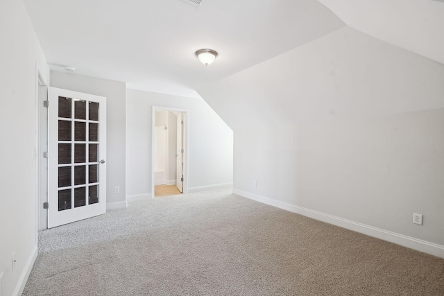 additional living space with baseboards, lofted ceiling, and carpet floors