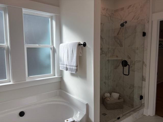 bathroom with a stall shower and a garden tub