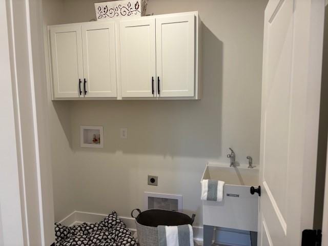 washroom with baseboards, cabinet space, hookup for an electric dryer, and hookup for a washing machine