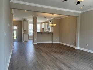 unfurnished living room with baseboards, dark wood finished floors, crown molding, and ceiling fan with notable chandelier