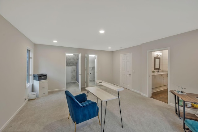 office area featuring recessed lighting, light colored carpet, baseboards, and a sink