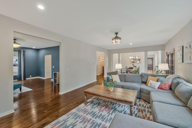 living room featuring recessed lighting, wood finished floors, baseboards, and ornate columns