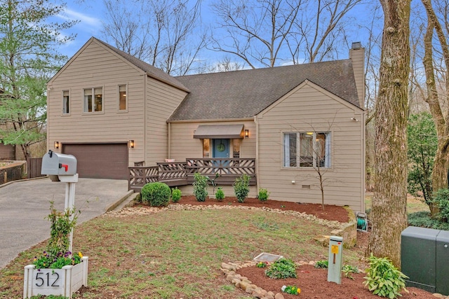 view of front of home featuring aphalt driveway, a chimney, a garage, and a shingled roof