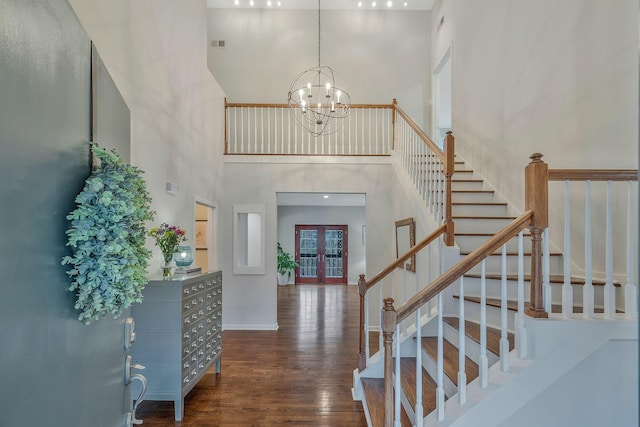 foyer entrance featuring baseboards, stairs, french doors, an inviting chandelier, and wood finished floors