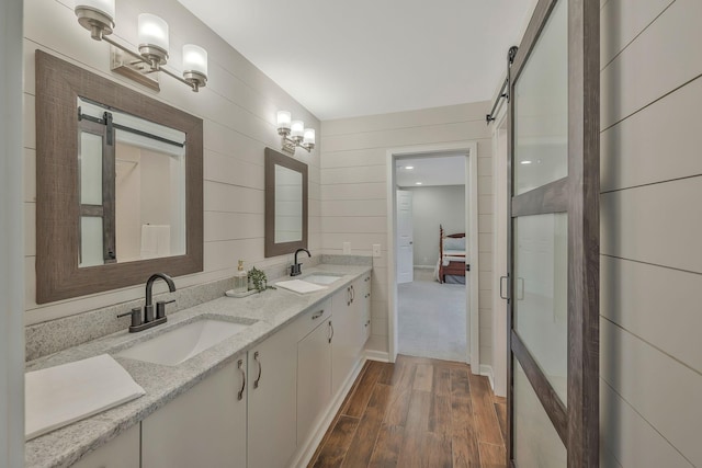 full bathroom featuring double vanity, wood finished floors, ensuite bathroom, and a sink