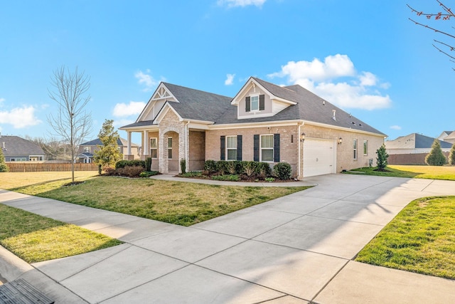 view of front facade with a front lawn, fence, concrete driveway, an attached garage, and brick siding