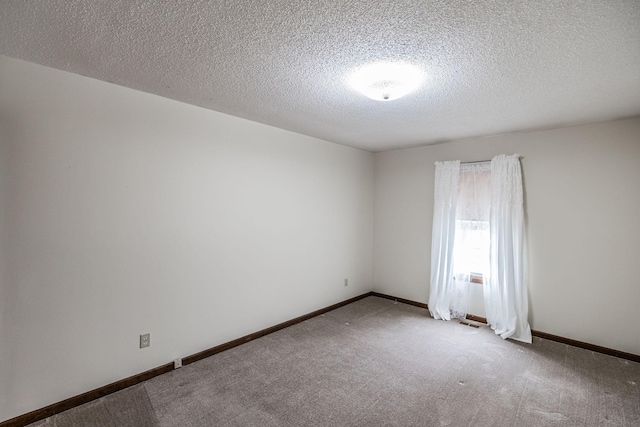 carpeted empty room featuring baseboards and a textured ceiling