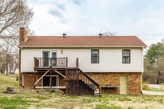 back of property with brick siding, stairway, roof with shingles, a chimney, and a deck