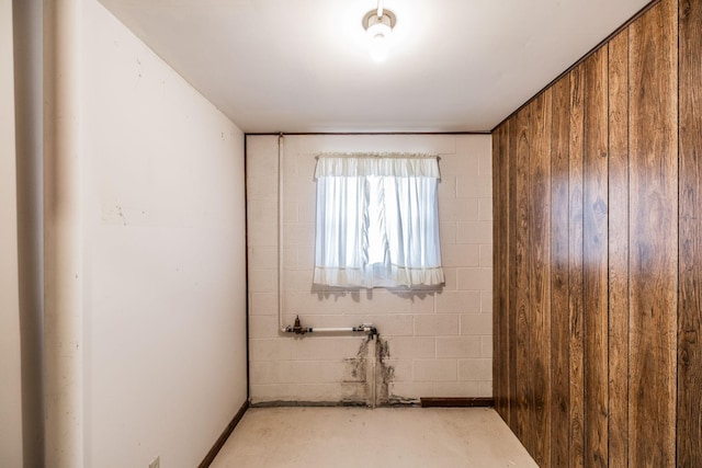 spare room with concrete floors and concrete block wall