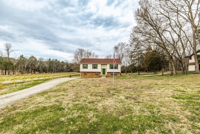 bi-level home with gravel driveway, a front yard, and crawl space