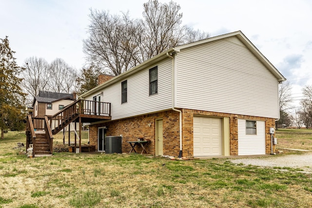 back of house featuring central air condition unit, stairway, an attached garage, a wooden deck, and brick siding